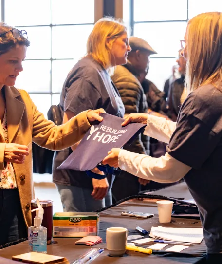 Conference attendee receiving registration materials from a conference volunteer