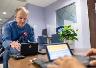 Image of man using digital assistance device to communicate